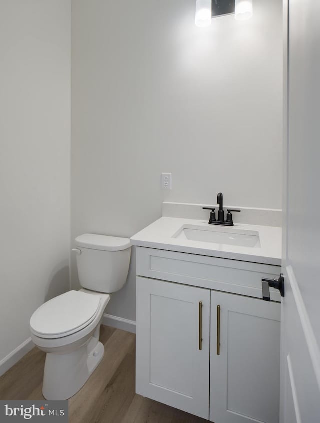 75 Cori Dr, Gilbertsville, PA 19525 - half bathroom with vanity, baseboards, toilet, and wood finished floors