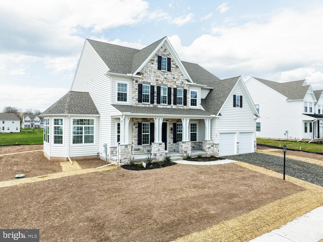 75 Cori Dr, Gilbertsville, PA 19525 - view of front of home featuring roof with shingles, a porch, stone siding, and an attached garage