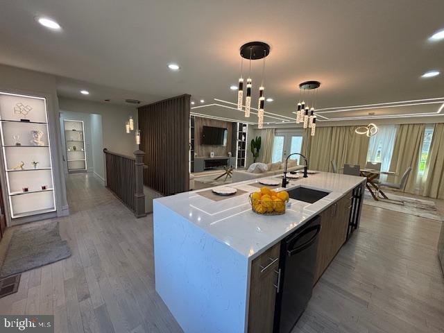 1242 Clearfield Cir, Lutherville Timonium, MD 21093 - kitchen with a large island with sink, a sink, an inviting chandelier, light wood-style floors, and black dishwasher