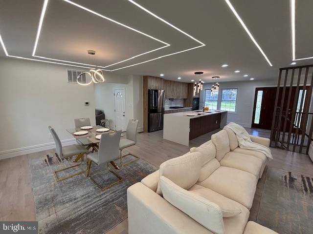 1242 Clearfield Cir, Lutherville Timonium, MD 21093 - living room featuring baseboards, a notable chandelier, light wood finished floors, and recessed lighting