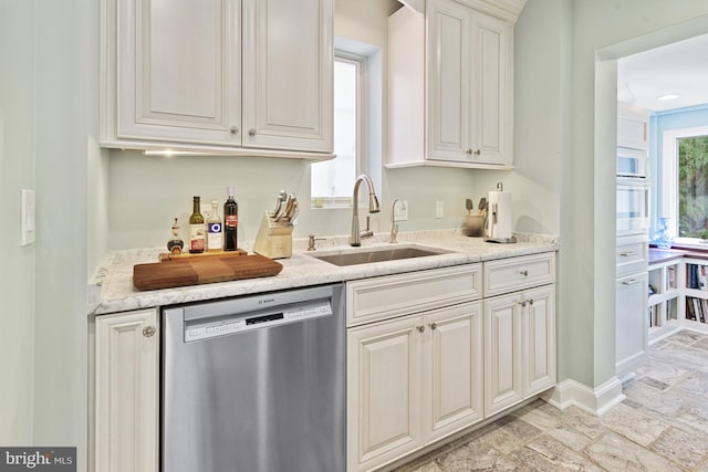 bar with stainless steel dishwasher, a sink, white oven, baseboards, and stone finish floor