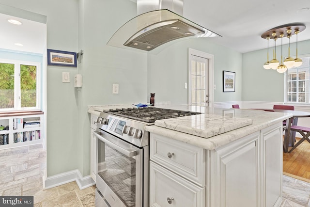 kitchen with white cabinets, island range hood, gas range, and light stone counters