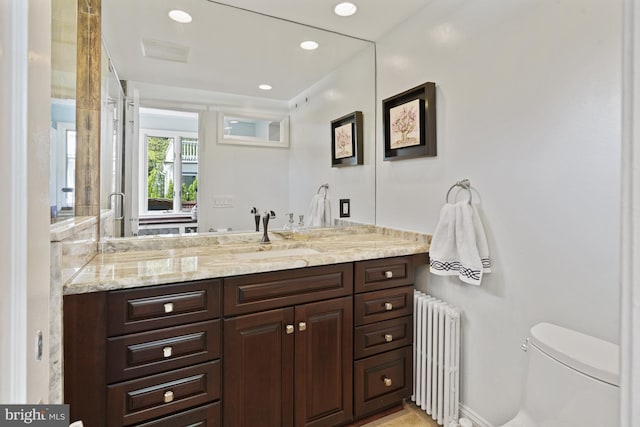 bathroom featuring radiator, toilet, vanity, and recessed lighting