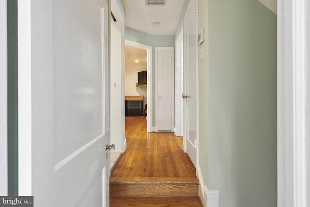 hall featuring wood finished floors and visible vents