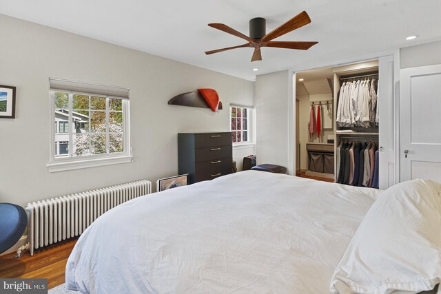 bedroom featuring radiator heating unit, wood finished floors, a closet, ceiling fan, and recessed lighting