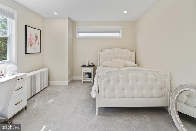 bedroom featuring light carpet, radiator heating unit, multiple windows, and recessed lighting