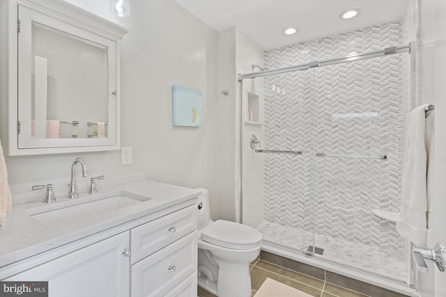bathroom with recessed lighting, toilet, vanity, and a stall shower