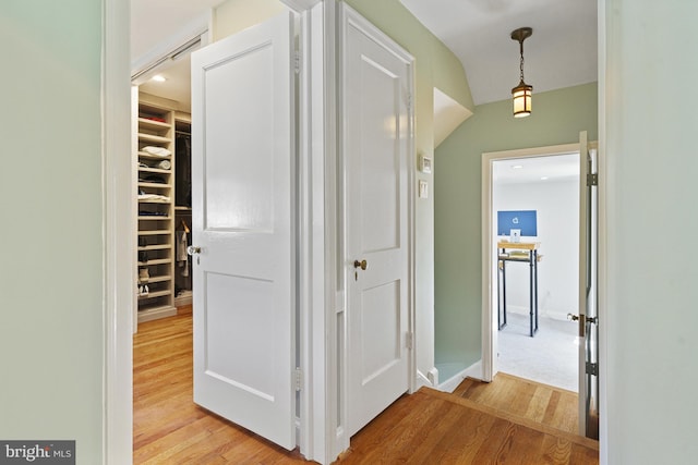 hall featuring light wood finished floors and baseboards
