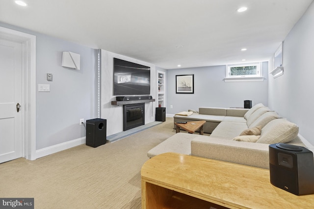 living area featuring recessed lighting, a glass covered fireplace, carpet flooring, and built in features