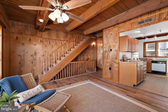 interior space with wooden walls, visible vents, beamed ceiling, light wood finished floors, and wood ceiling