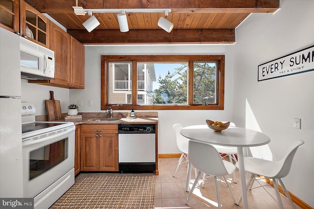 kitchen featuring white appliances, wood ceiling, light tile patterned flooring, a sink, and beam ceiling