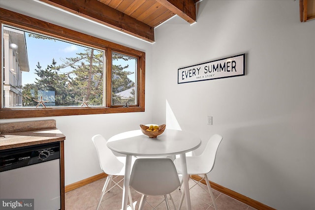 dining area featuring light tile patterned floors, baseboards, and beamed ceiling