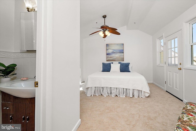 carpeted bedroom featuring a sink and vaulted ceiling