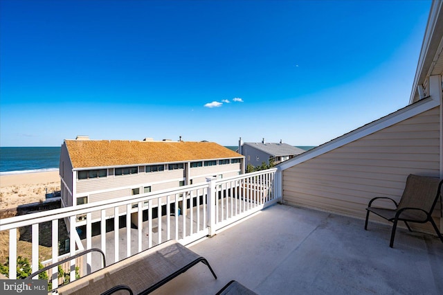 balcony featuring a water view and a view of the beach