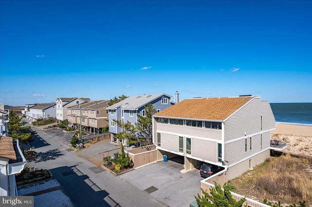birds eye view of property featuring a water view, a residential view, and a view of the beach