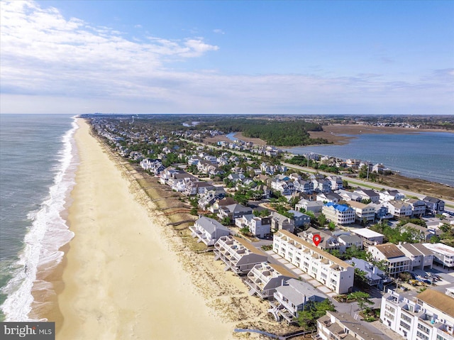 birds eye view of property with a water view and a beach view