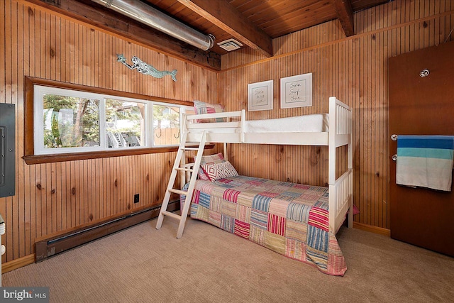 bedroom featuring wooden walls, beam ceiling, carpet floors, and baseboard heating