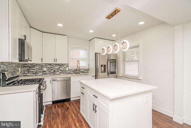 kitchen with stainless steel appliances, tasteful backsplash, dark wood-style flooring, light countertops, and recessed lighting