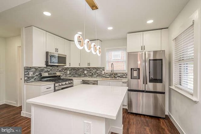 kitchen with appliances with stainless steel finishes, a sink, backsplash, dark wood-type flooring, and recessed lighting