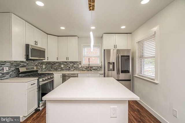 kitchen featuring appliances with stainless steel finishes, tasteful backsplash, white cabinetry, light countertops, and recessed lighting