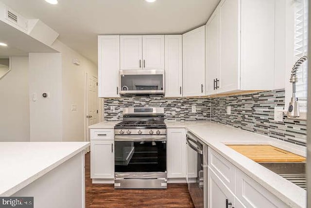 kitchen featuring stainless steel appliances, white cabinets, light countertops, and recessed lighting