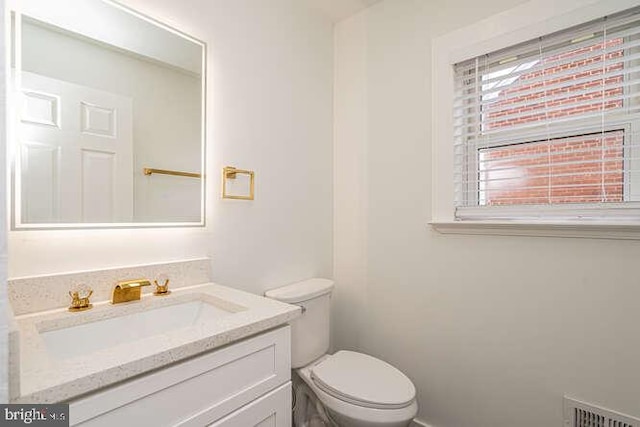 half bathroom with toilet and vanity