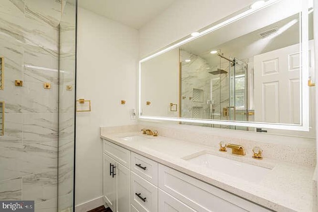 full bath featuring a marble finish shower and double vanity