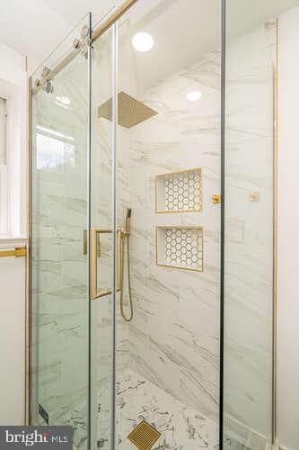 full bath with a marble finish shower