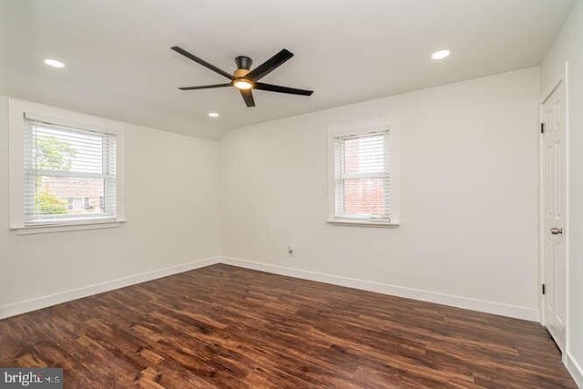 empty room featuring healthy amount of natural light, ceiling fan, dark wood finished floors, recessed lighting, and baseboards