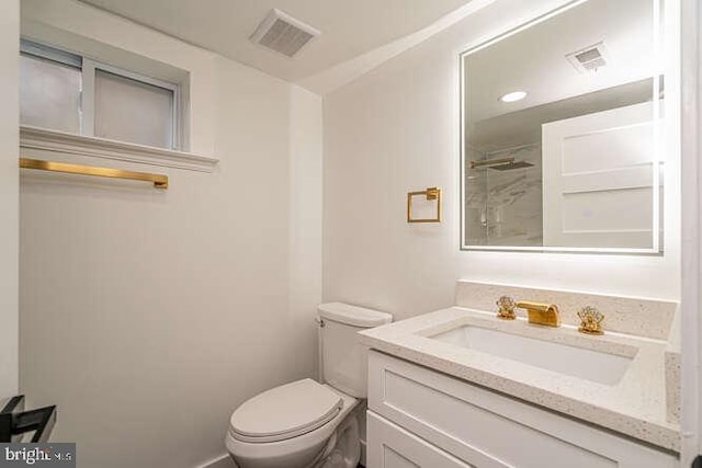 bathroom featuring toilet, vanity, and baseboards