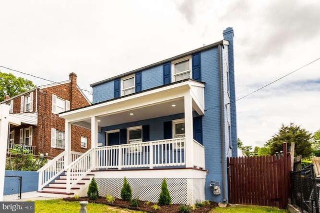 view of front facade featuring covered porch and fence
