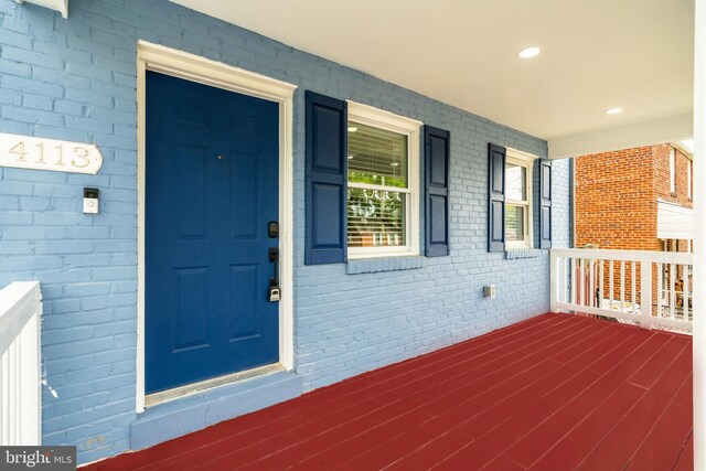 property entrance featuring brick siding and covered porch