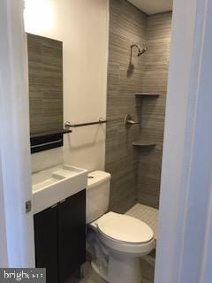 2025 N Woodstock St, Philadelphia, PA 19121 - bathroom with toilet, tiled shower, and vanity