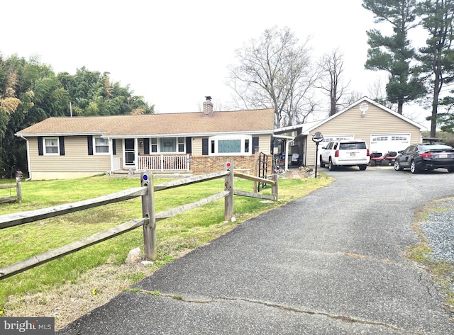 single story home featuring a chimney, a detached garage, a front yard, fence, and a porch