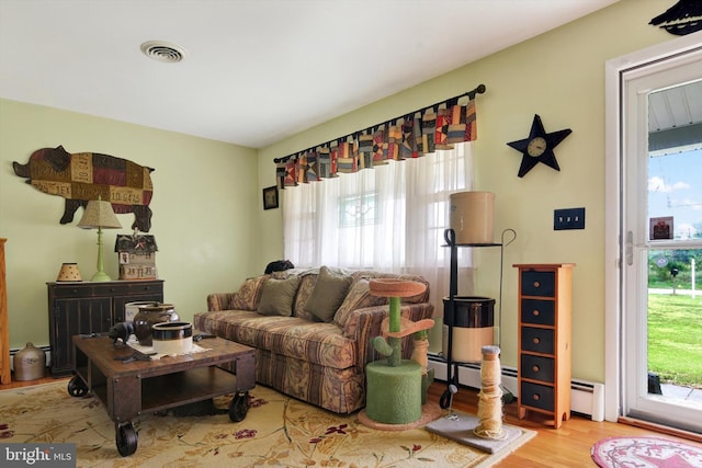 living area featuring visible vents and wood finished floors