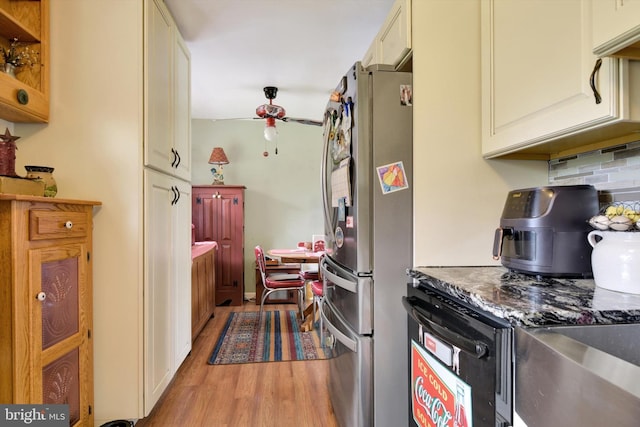 kitchen featuring tasteful backsplash, ceiling fan, freestanding refrigerator, light wood-type flooring, and cream cabinets