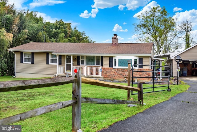 ranch-style house with a chimney, fence, covered porch, and a front lawn