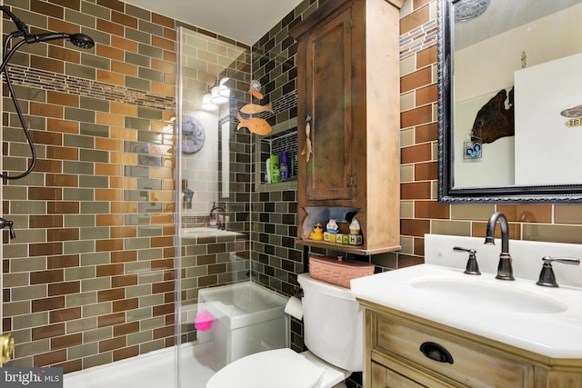 bathroom featuring toilet, a stall shower, tile walls, and vanity