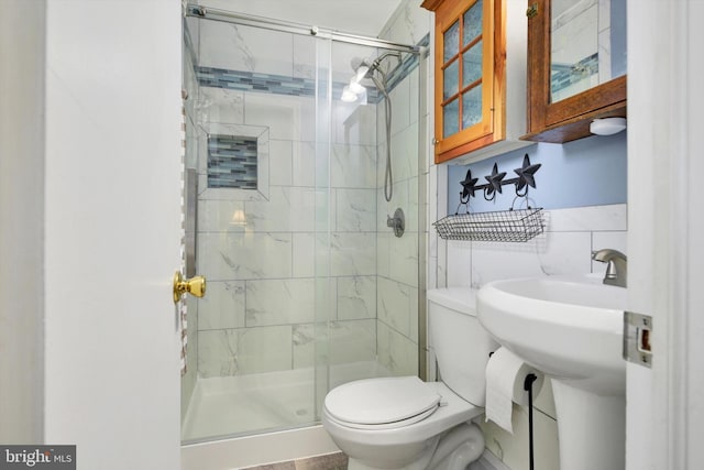 full bath featuring toilet, a shower stall, and tile walls