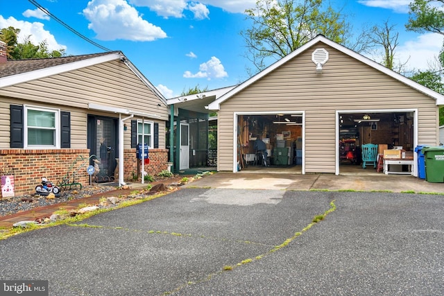 view of front of house featuring a garage, brick siding, and an outdoor structure