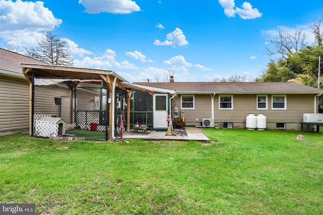 back of house featuring a lawn, a patio area, and a sunroom