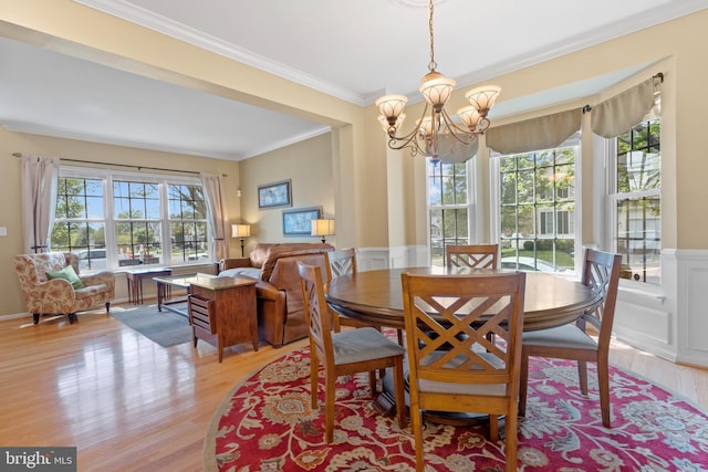 15008 Seneca Knoll Way, Haymarket, VA 20169 - dining space featuring a wainscoted wall, light wood-style flooring, a notable chandelier, and crown molding