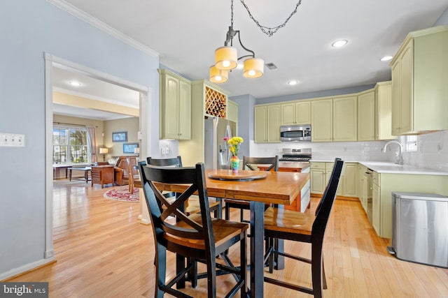 15008 Seneca Knoll Way, Haymarket, VA 20169 - kitchen featuring stainless steel appliances, ornamental molding, green cabinets, and a sink