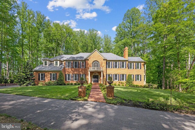 6601 Rutledge Dr, Fairfax Station, VA 22039 - view of front of house with a chimney, brick siding, and a front yard