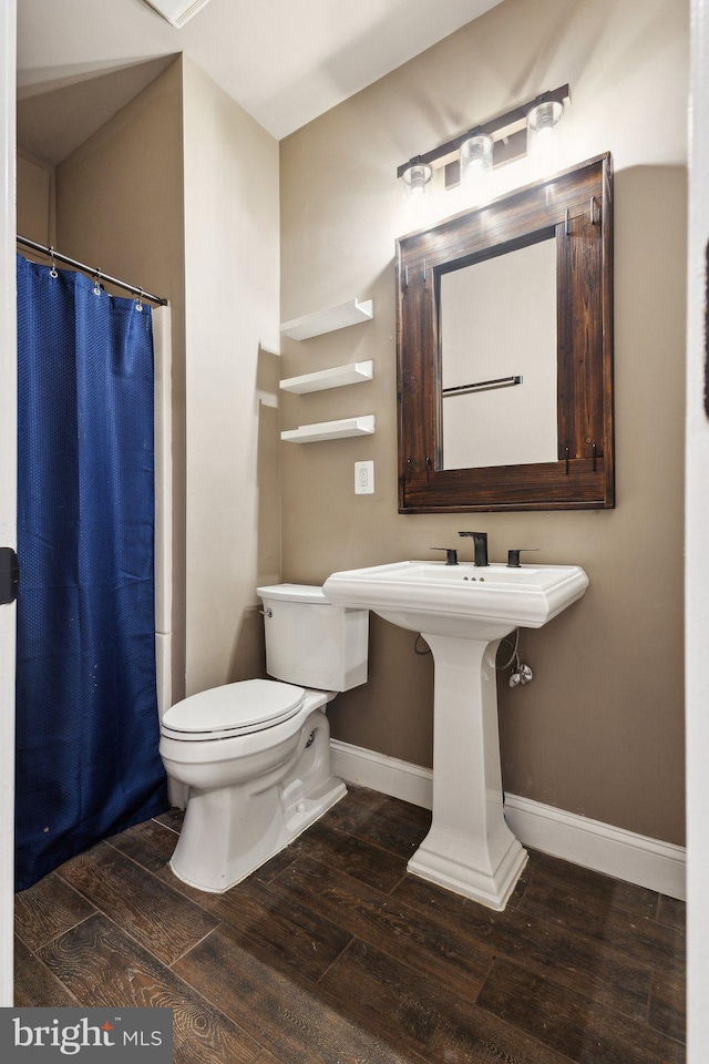6601 Rutledge Dr, Fairfax Station, VA 22039 - bathroom with baseboards, toilet, wood finished floors, and a shower with shower curtain
