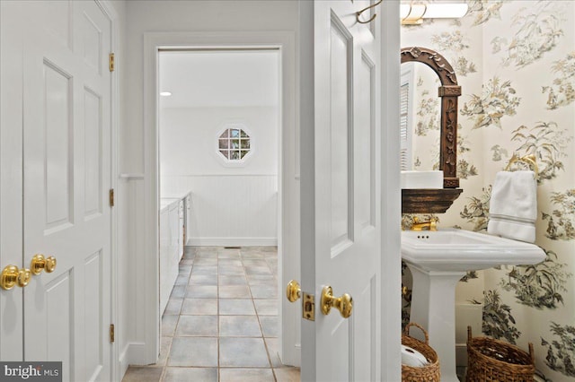bathroom featuring tile patterned floors and a wainscoted wall