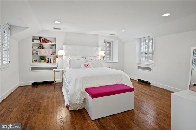 bedroom with visible vents, baseboards, vaulted ceiling, and wood finished floors