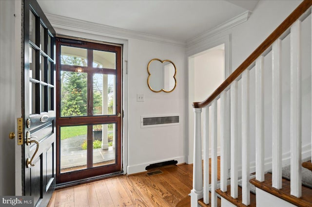 entryway featuring a wealth of natural light, stairway, light wood-style floors, and crown molding