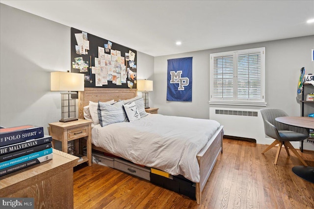 bedroom with recessed lighting, radiator, and wood finished floors
