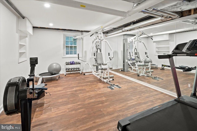 exercise room with baseboards, recessed lighting, and wood finished floors